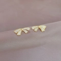 Elegante goldene Schleifenohrringe mit Kristallen auf violettem Samthintergrund flach - Vollbesetzter Diamant-Schleifenstil (A109)