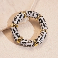 Détail macro des perles en acrylique à motif léopard et intercalaires dorés - Imprimé Léopard Blanc (Bracelet-Blanc) / Blanc