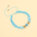 Detailansicht des dreilagigen hellblauen Perlenarmbands mit goldenen Böser-Blick-Perlen - See Blau