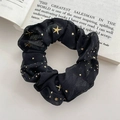 Elegant black scrunchie with gold star pattern displayed on an open vintage book page - FQ1068A Black Star Scrunchie