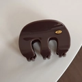 Detail of dark brown hair claw clip with golden oval Love label on polished surface - Wavy M-Shaped / Khaki
