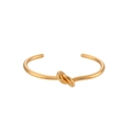 Minimalist 18K gold plated stainless steel knot cuff bracelet on white background - Gold