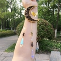 Detail of golden moon and butterfly suncatcher with crystals and prisms in natural light - Tiger Eye Stone Bracelet
