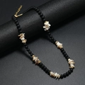 Collana bohémien con perle nere opache e frammenti di conchiglia su supporto nero professionale - Colore conchiglia