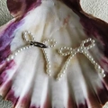 Pair of pearl bow accessories with silver safety pins on a decorative seashell - 46-Bow Beige (With Brooch)