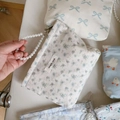 Detail of floral fabric pouch featuring elegant pearl handle and simple wish label - Light Blue Floral