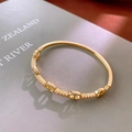 Detail shot of a gold-plated pig nose link bracelet with sparkling cubic zirconia accents - Pig Nose Style / Gold