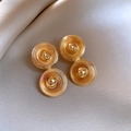 Détail de boucles d'oreilles dorées à double disque en acrylique sur tissu en soie mauve - Style Cercles Concentriques Spirale (39) / Or