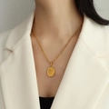 Collana con ciondolo ovale dorato con incisione floreale su catena Figaro indossata - 50cm / Fiore di Prugno Dorato (P1023)