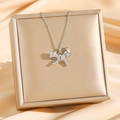 Exquisite bow pendant necklace with sparkling zircons displayed on a champagne gift box - Silver