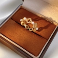 Gros plan sur une bague dorée avec perles et zircons dans un écrin à bijoux - Or (Plaqué Or Véritable)