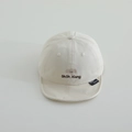 Detailaufnahme der Elefantenstickerei und des Markenlabels auf dem Baby-Sonnenhut - 50cm 1-3 Jahre / Gebrochenes Weiß