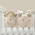 Close-up of cotton baby crib organizer featuring moon and star patterns and dual pockets - Moon