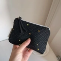 Close-up of black knitted pouch with colorful polka dots and white zipper closure - Black