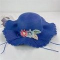 Detail view of blue wide-brim straw hat featuring delicate 3D floral embroidery and wavy edge - Navy Blue