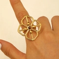 Detail of a large hollow gold flower ring featuring fine twisted rope edges and a brown stone - Tea Crystal Hollow Flower (4373)