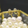 Elegant gold square pearl earrings featuring large white pearls on a black background - Geometric Irregular Square Earrings
