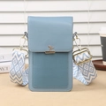 Light blue crossbody phone bag with leaf metal buckle and woven strap on a wooden desk - Blue