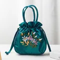 Dark green silk drawstring handbag featuring intricate colorful floral embroidery detail - Dark Green