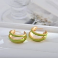 Macro shot of stylish gold and grass green triple-layer C-shape hoop earrings - Green