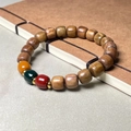 Ebony and pear wood beaded bracelet with tricolor accent beads on a vintage book - 8x9mm Three Colors Vintage Beads / Green Sandalwood