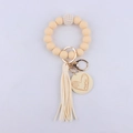 Dettaglio portachiavi in silicone beige con nappa e ciondolo a cuore inciso Mama - Beige