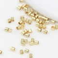 Macro shot of 18K gold plated metal crimp beads for DIY jewelry bracelet making - 2x2mm / 14K Gold