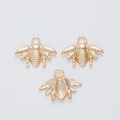 Detailed macro view of three golden bee-shaped alloy charms with intricate textures - KC Gold