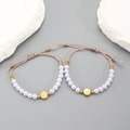 Close-up of pink woven bracelets with white pearls and gold metal charms on stone - Pink Braided Rope Artificial Pearl Style / Pink (1675)