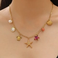 Dettaglio della collana oceano in acciaio inox oro 18K con stelle marine e perle - Ciondolo Oceano Tropicale (06) / Oro