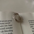 Silver metallic ear cuff with irregular hammered texture on an open book page - Irregular Hammered Ear Cuff (J1965)