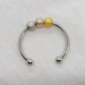 Macro view of tri-color frosted spinning beads on a polished stainless steel open ring - Adjustable Open / Mixed Colors (Copper)
