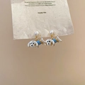 Detail van schattige teckel oorbellen met blauw emaille, parels en zirkoon op kaart - 925 Sterling zilveren oorknopjes - Goud - Wit & Blauw - Hond (Echt gouden plating)