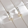 Macro shot of elegant pearl drop earrings with rectangular crystal and silver frame - Silver with Zircon
