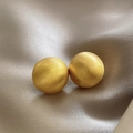 Macro shot of matte gold spherical stud earrings on premium champagne velvet background - A1040 Gold Matte Ball Studs