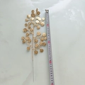 Vue détaillée d'une branche de feuilles dorées avec pièces de fortune et ruban à mesurer - Caractère Fu Doré