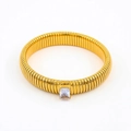 Detailed macro of gold snake-coil flexible bracelet featuring a rectangular zircon stone - 10mm Width x 18cm Circumference / White