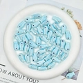Macro detail of light blue ceramic fish beads for DIY jewelry making on white tray - Light Lake Blue