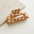 Detail shot of the checkered hair claw clip with orange and cream polished finish - Hollow Orange