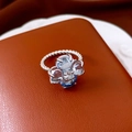 Dettaglio di anello a fiore con gemme azzurre e fascia d'argento intrecciata - Argento/Blu
