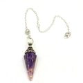 Detailed macro of a purple amethyst hexagonal crystal pendulum with silver flower cap - Purple