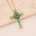 Collana a croce con zirconi verdi su pietra di marmo in una foto di natura morta - Verde