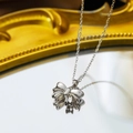 Silver bow pendant necklace in polished titanium steel on a vintage mirror surface - Silver