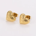 Detalle de pendientes de corazón dorados con textura martillada en fondo blanco - Dorado