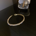 Detailed shot of gold-plated tennis bracelet with sparkling cubic zirconia on black mirror - Gold Round (Style 2)
