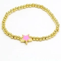 Detail of a gold beaded bracelet featuring a pink enamel star pendant with metal shine - Pink