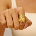 Detailed view of a gold starfish ring with hammered texture on a model's finger - Fish Style (11389)