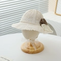 Close-up of floral lace bucket hat with brown polka dot bow and pom pom trim - 50-52CM / Beige