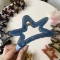 Detail of star-shaped Morandi blue hair claw clip with golden metal spring and glossy finish - 11cm / Haze Blue