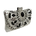 Detailed close-up of a silver evening clutch featuring ornate beads and a large black gemstone - Silver